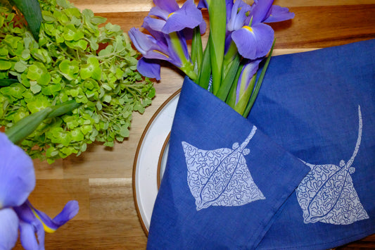 Lifestyle table display featuring &BEYOND Eagle Ray Blues napkins in a cozy dining setup.
