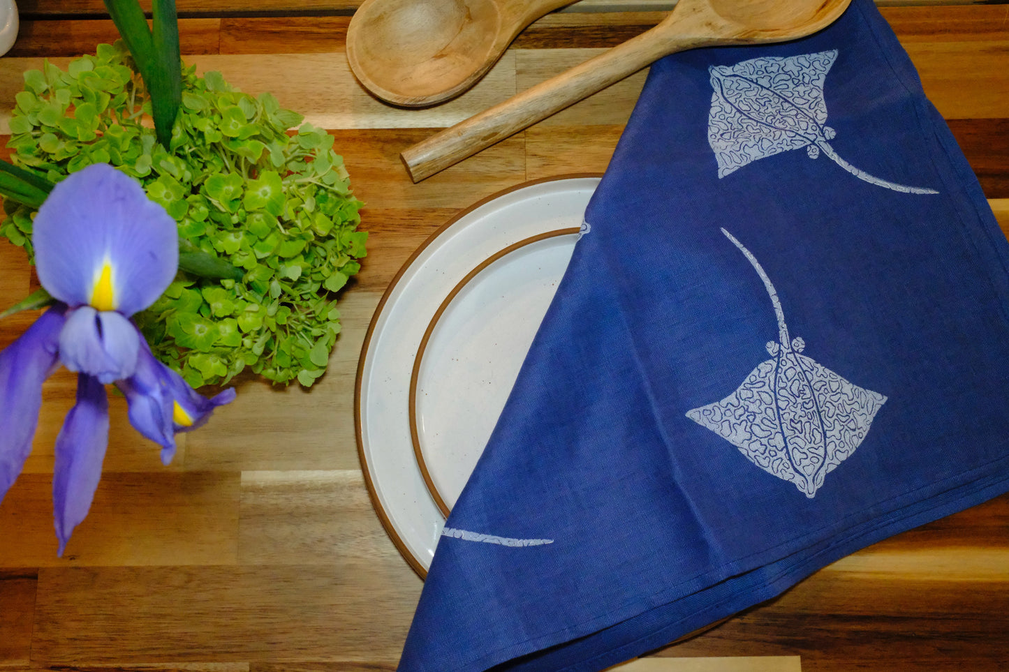 &BEYOND Eagle Ray Blues linen napkin styled with a plate and silverware.