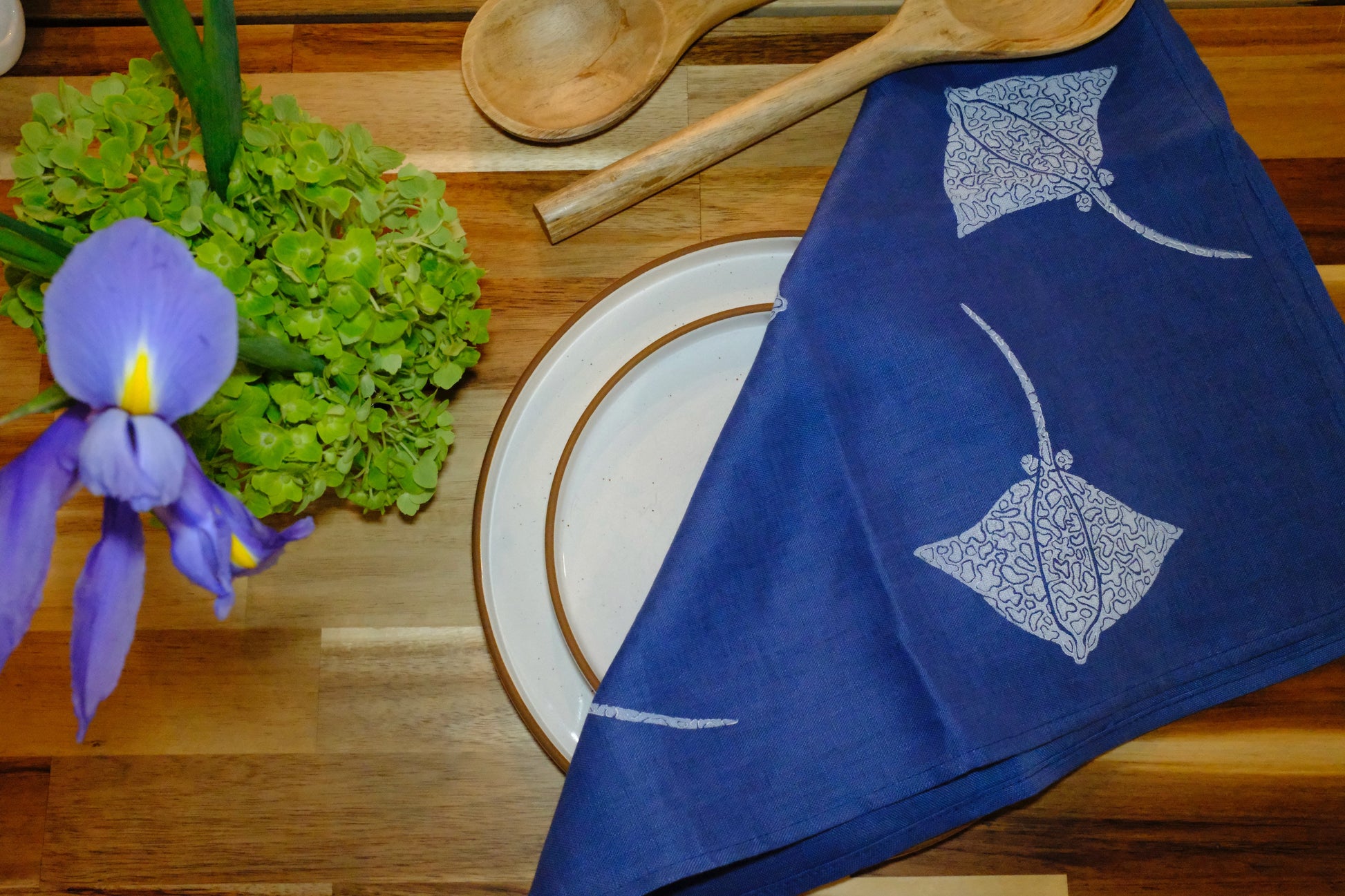 &BEYOND Eagle Ray Blues linen napkin styled with a plate and silverware.