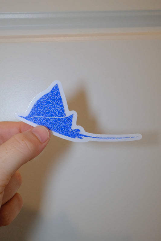 Hand holding an &BEYOND Eagle Ray Swimming ocean-inspired vinyl sticker.