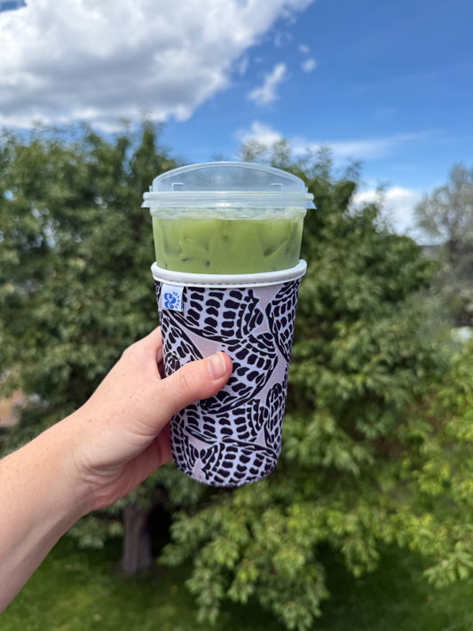 Close-up of the &BEYOND Hebrew Shell coozie showing the detailed seashell print.