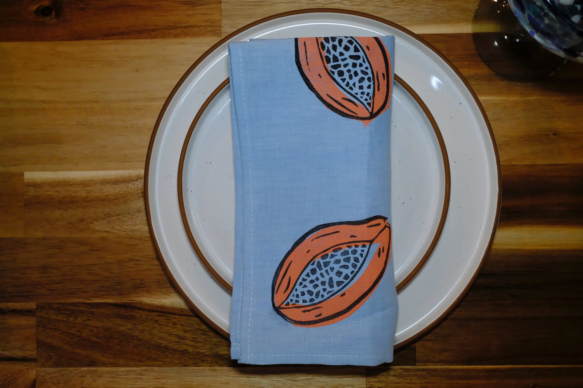 &BEYOND Papaya Dream linen napkin placed on a decorative plate.