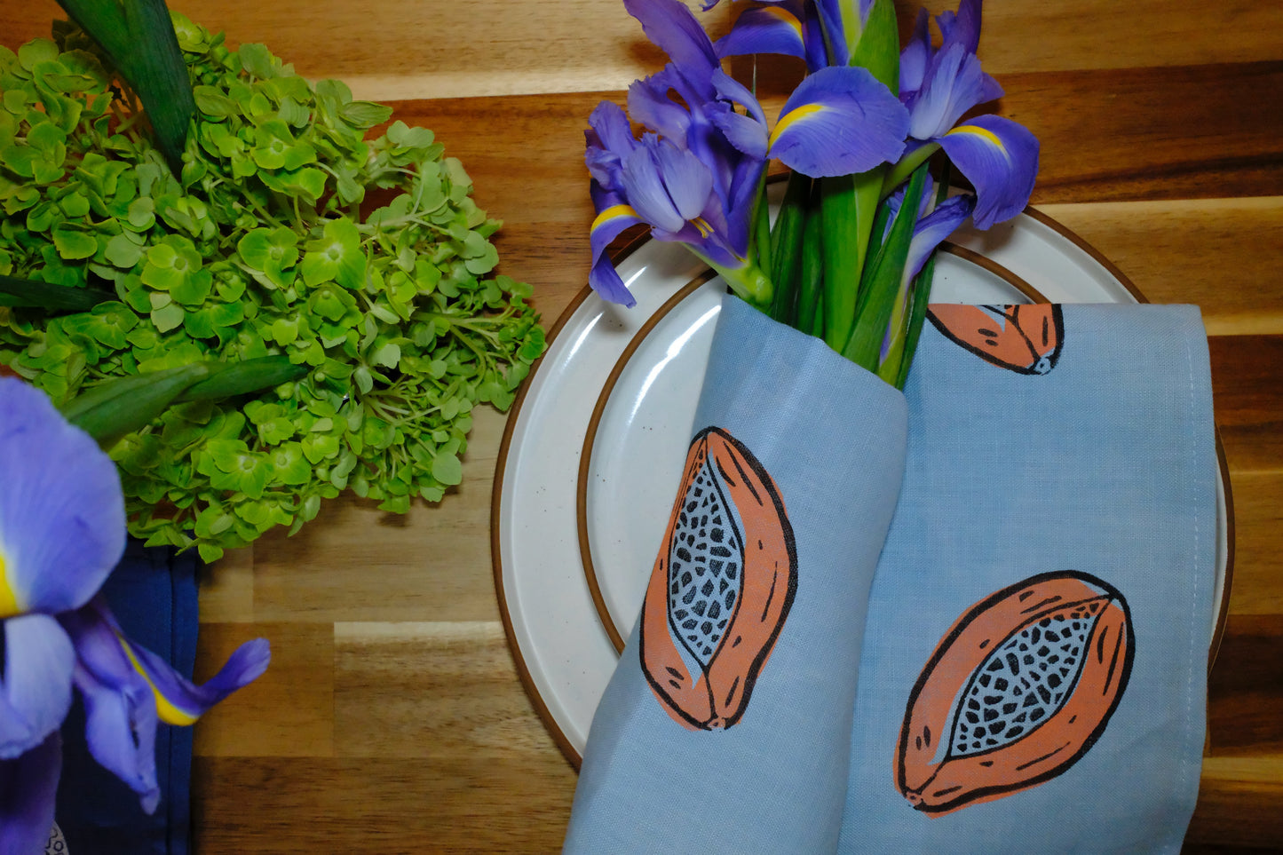 Lifestyle table display featuring &BEYOND Papaya Dream linen napkins in a warm dining scene.